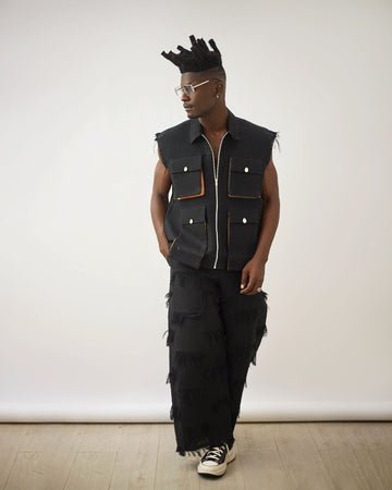 Chaqueta negra sin mangas con flecos y pantalones Aso Oke